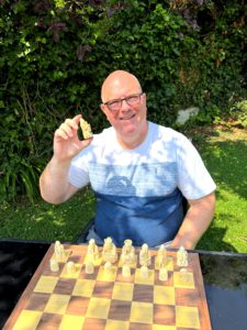 Gregory Hunt holding a carved Lewis-style chess knight, representing the transformative mediator in ADR - empathetic, unconventional, and emotionally attuned.